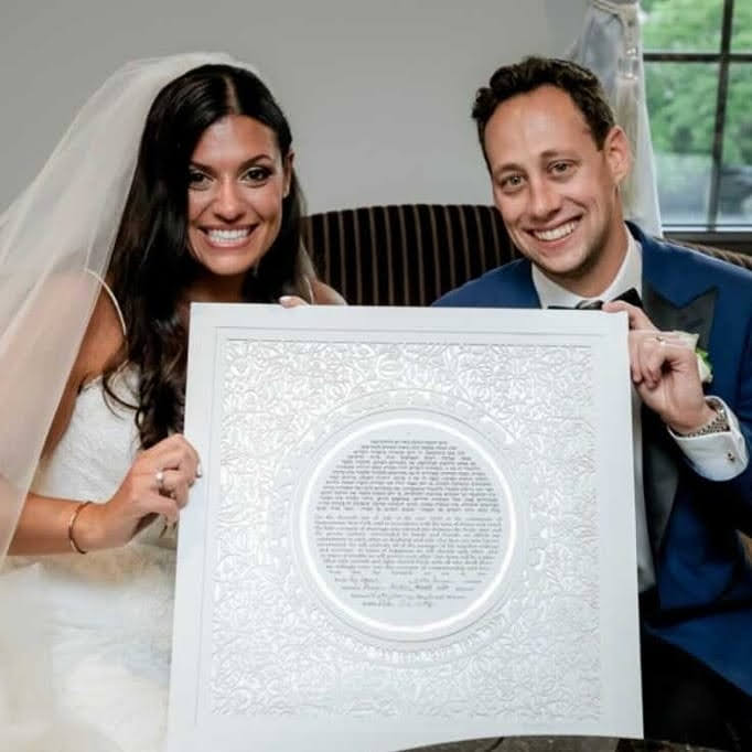 A couple excitedly discussing their vision for their custom Ketubah with an artist.